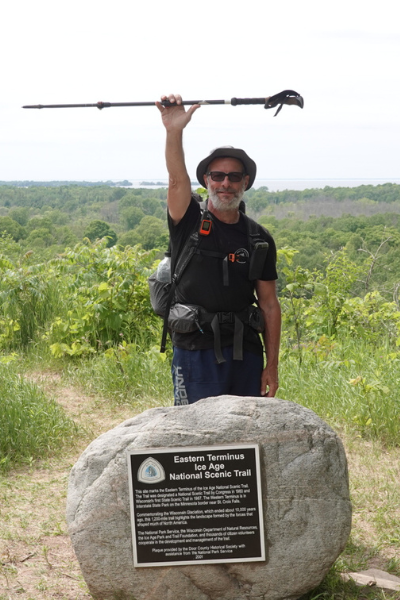 Photo of Morehouse posing behind the "Eastern Terminus Ice Age National Scenic Trail" sign at the end of his thru-hike. Photo by Dale Morehouse.
