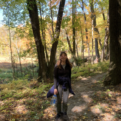 A woman smiles during a fall hike.