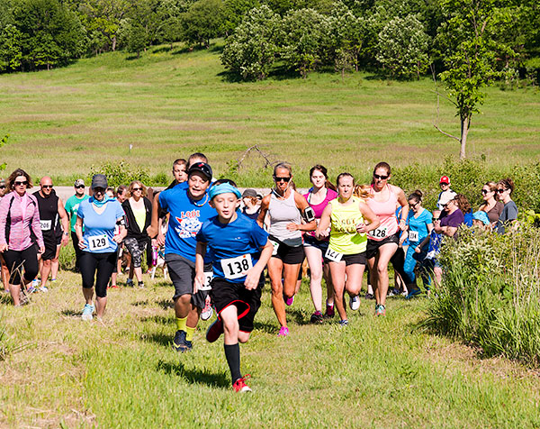 Kids and adults participate in the Lodi Valley Chapters Mammoth Fun Run and Hike. A kid in a blue shirt leads the way during the running event.