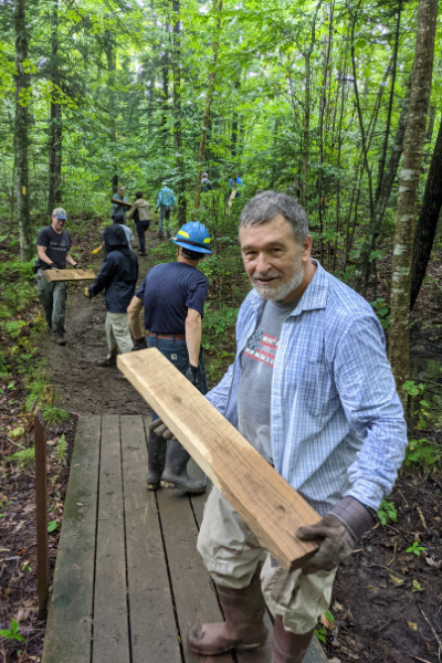 Boards being passed down a line of volunteers on their way to be installed as boardwalk. Photo by Dave Caliebe.