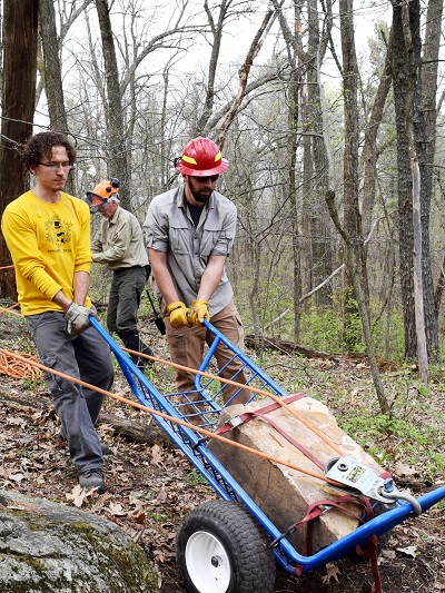 A volunteer and trailbuilding staff move a granite boulder to a more ideal location. Photo courtesy of Dave Caliebe.
