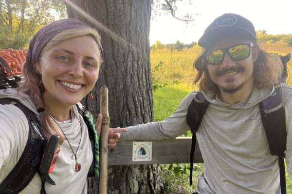Lorenz and Cole smiling in front of an Ice Age National Scenic Trail sign. Photo by: Stephanie Lorenz and Chandler Cole.