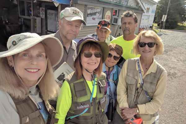 Thousand-Milers Mary Cieslewicz (left), Janet Carriveau, Barb Roeder, and Nancy Radke (front row) learned the history of Lublin, Wisconsin from Richard Pulcher, Village Trustee, Dick Miller, and Jerry Kolven, Village President (back row). 
 Photo (August 23, 2019) by Mary Cieslewicz.