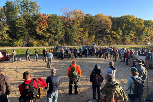 A group of volunteers gather in a circle at the Cross Plains Segment for a morning meeting prior to the Trailbuilding event.