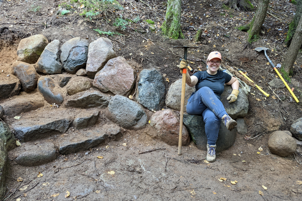 A volunteer shows off the new stone staircase and retaining wall. Photo by Dave Caliebe.