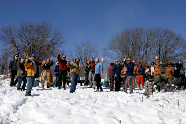 Volunteers smile and wave at the camera during lunch.