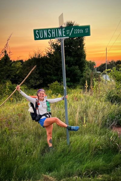 Lorenz posing in front of a street sign that shares her trail name: "Sunshine." Photo by: Chandler Cole.